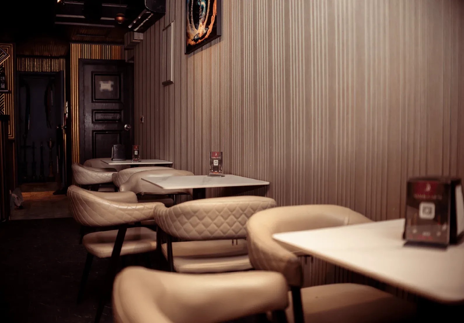 Cream booths and warm wood panelling inside Malika Lounge